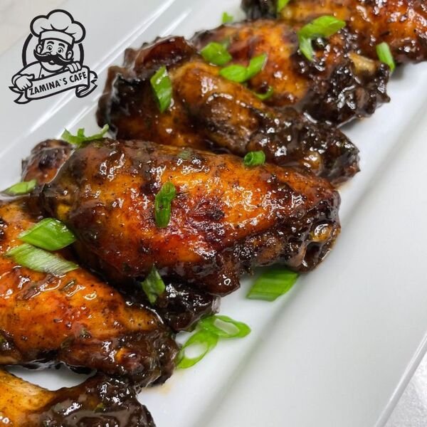 Savor our Jerk Wings, an asian chicken dish with a perfect blend of spices and a hint of sweetness, ideal for sharing.